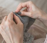 hands knitting closeup gray